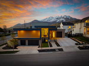 Modern home featuring a mountain view, driveway, and fence
