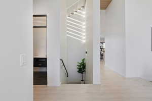 Hallway featuring a high ceiling, wood finished floors, and baseboards