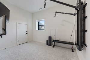 Exercise room featuring baseboards, visible vents, and carpet flooring