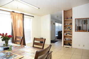 Dining space with light tile patterned floors, visible vents, and baseboards