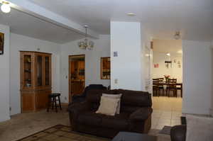 Living area featuring an inviting chandelier and lofted ceiling with beams