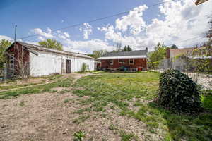 View of yard featuring fence and an outdoor structure