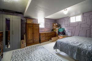 Bedroom featuring a textured ceiling and multiple windows