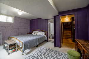 Bedroom with wooden walls, a textured ceiling, and concrete floors