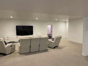 Living area featuring light colored carpet, recessed lighting, and baseboards