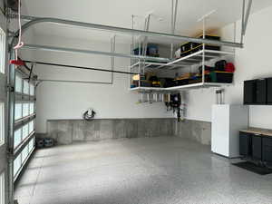 Garage with a garage door opener and freestanding refrigerator