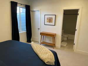 Bedroom with baseboards, ensuite bath, tile patterned flooring, and carpet flooring