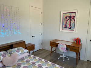 Bedroom with baseboards and wood finished floors