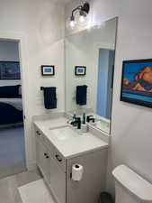 Ensuite bathroom with toilet, ensuite bath, and vanity