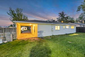 Rear view of house with a lawn, a fenced backyard, and brick siding