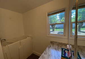 Laundry room with baseboards, a healthy amount of sunlight, and dark wood finished floors