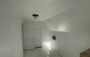 Additional living space with lofted ceiling and baseboards