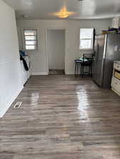 Unfurnished dining area with dark wood-type flooring, visible vents, separate washer and dryer, and a textured ceiling