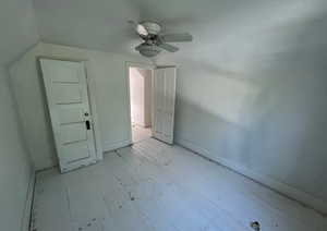 Unfurnished bedroom with a ceiling fan, light wood-style flooring, lofted ceiling, and baseboards