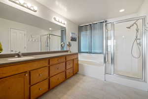 Bathroom with vanity, a shower stall, and a garden tub