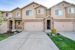 View of front facade featuring stucco siding, concrete driveway, and an attached garage