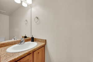 Half bath featuring toilet, visible vents, and vanity