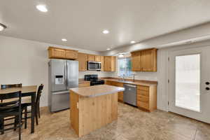 Kitchen featuring recessed lighting, a sink, a kitchen island, and stainless steel appliances
