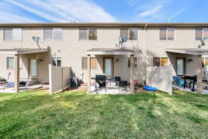 Rear view of house featuring fence, cooling unit, a yard, and a patio area