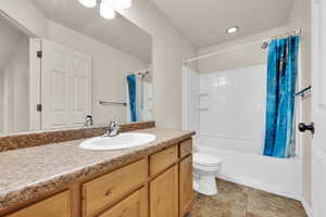 Bathroom with shower / bath combo with shower curtain, toilet, and vanity