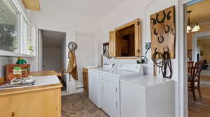 Clothes washing area featuring washing machine and dryer and ornamental molding