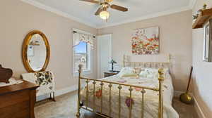 Bedroom with a ceiling fan, baseboards, carpet, and ornamental molding