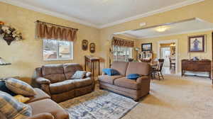 Living area featuring carpet floors and crown molding