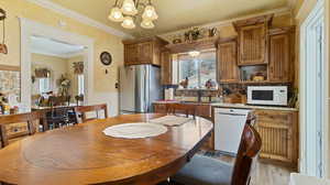 Dining room with a chandelier, light wood-style flooring, and crown molding