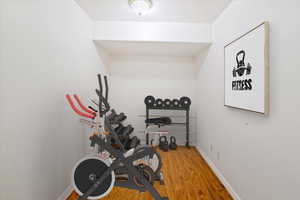 Virtually staged exercise area in the basement with wood finished floors.