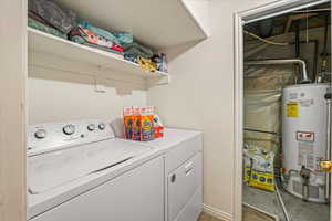 Laundry area featuring water heater, laundry area, and independent washer and dryer