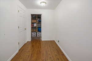 Hallway with wood finished floors and baseboards
