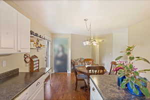 Dining area featuring dark wood-style floors, an inviting chandelier.
