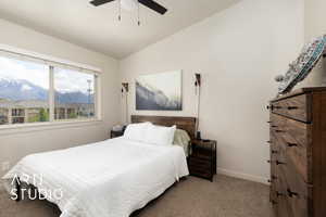 Bedroom with carpet flooring, a mountain view, a ceiling fan, baseboards, and lofted ceiling