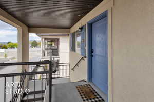 Doorway to property with stucco siding and a balcony