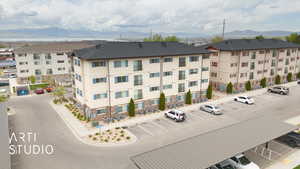 View of building exterior with uncovered parking and a mountain view
