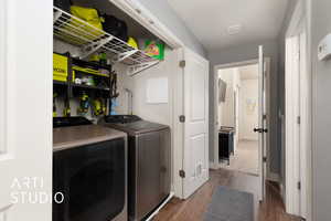 Laundry area featuring dark wood-style floors, laundry area, and washer and clothes dryer