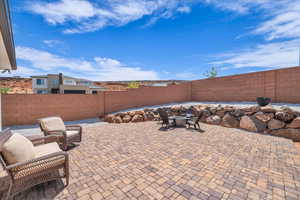 View of patio with a fenced backyard and an outdoor fire pit