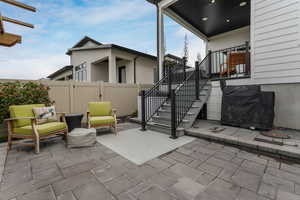 A spacious backyard patio featuring a built-in storage shed tucked neatly beneath the deck above, maximizing both style and functionality.