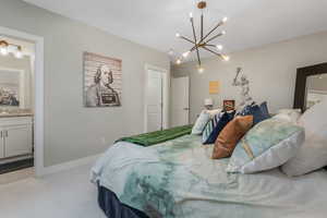 A beautifully designed bedroom featuring an elegant chandelier, a private en suite bathroom, and a generous layout for ultimate comfort.