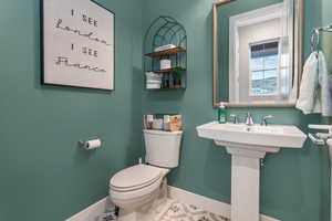 A conveniently located half bath near the entry provides both practicality and thoughtful design, offering easy access for guests while seamlessly blending into the home's layout.