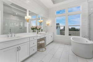 This primary en suite bathroom is bathed in natural light, creating a bright and airy atmosphere with a timeless design.