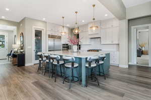 A kitchen adorned with stunning pendant lights and recessed lighting, creating a timeless and elegant ambiance.