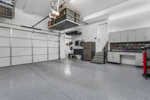 An impressive oversized three-car garage featuring four hydraulic lift storage systems, maximizing space and functionality for vehicles and equipment.