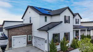 This high-end modern farmhouse, thoughtfully designed with custom finishes, offers an open-concept layout, vaulted ceilings, and top-tier appliances. Warm wood accents and oversized windows create an inviting yet sophisticated atmosphere, perfect for styl