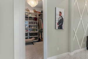 A spacious primary en suite closet, discreetly tucked behind a hidden shelving entrance, complete with a convenient washer and dryer.