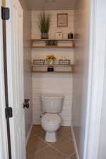 Bathroom featuring tile patterned floors, toilet, and baseboards