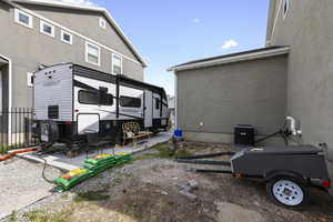 Rear view of house with central air condition unit, stucco siding, and fence
