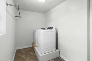 Clothes washing area with baseboards, separate washer and dryer, and laundry area