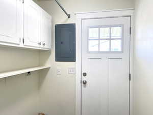 Washroom featuring electric panel and cabinet space