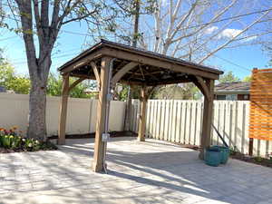 View of patio featuring fence and a gazebo
